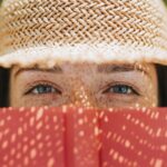 Closeup of woman covering her face with a red book